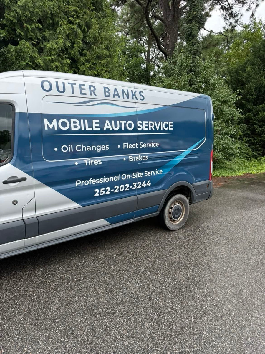 Angled view of the van wrap showing the service list and phone number