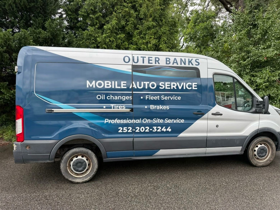 Side profile of the Outer Banks Mobile Auto Service van wrap with the service list and phone number