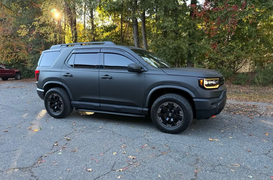 SUV wrapped in matte gray with gloss black accents, full side view
