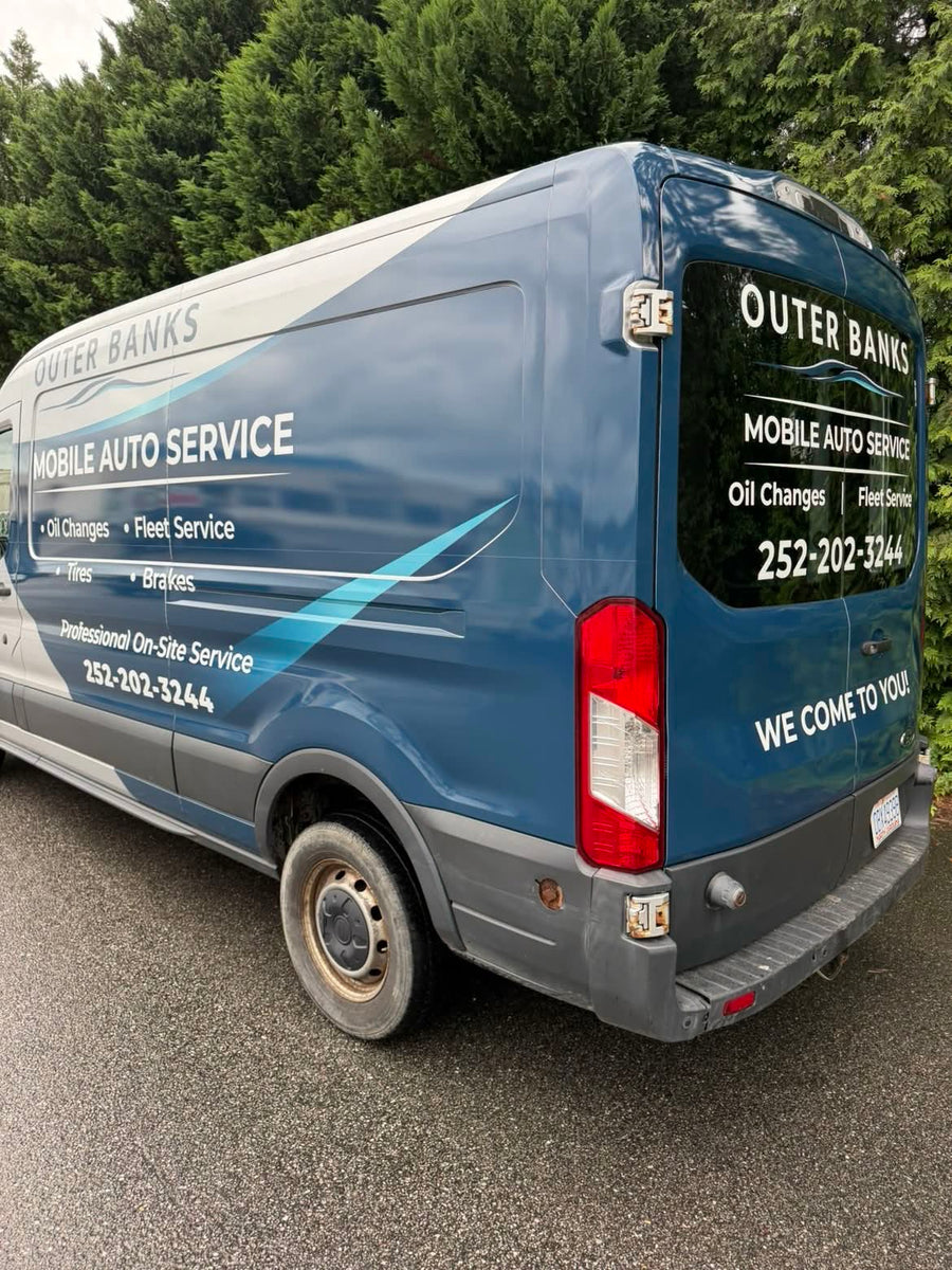 Rear three-quarter view of the wrapped van with We Come To You lettering